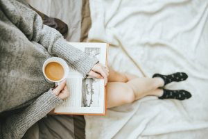Woman drinks coffee while reading a book