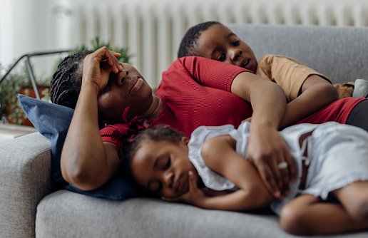 Mom is laying with her kids, trying to cope with burnout