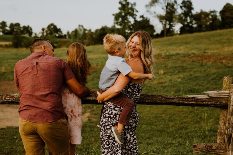 Libby Ward holder her son while her husband and daughter look into the distance.